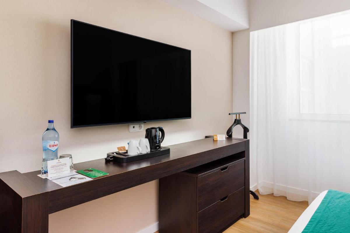 Uma televisão e/ou sistema de entretenimento em Jupiter Algarve Hotel - Beach & Spa
