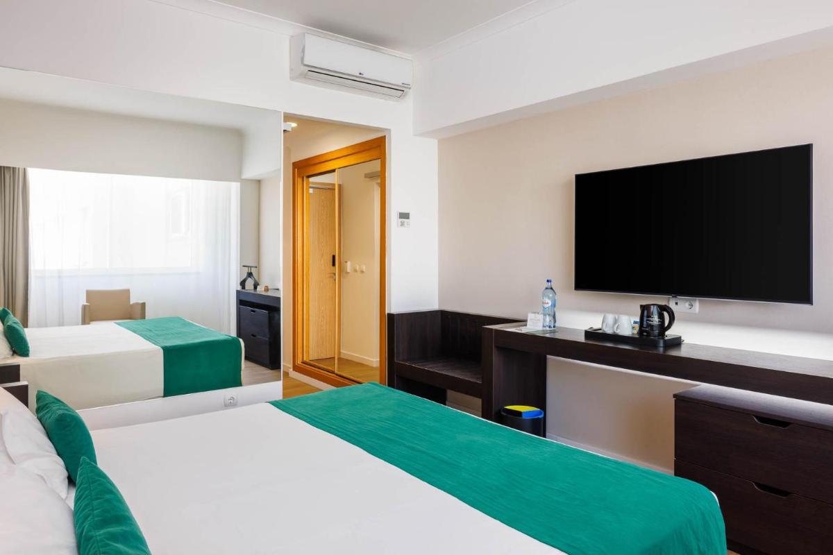 Uma televisão e/ou sistema de entretenimento em Jupiter Algarve Hotel - Beach & Spa