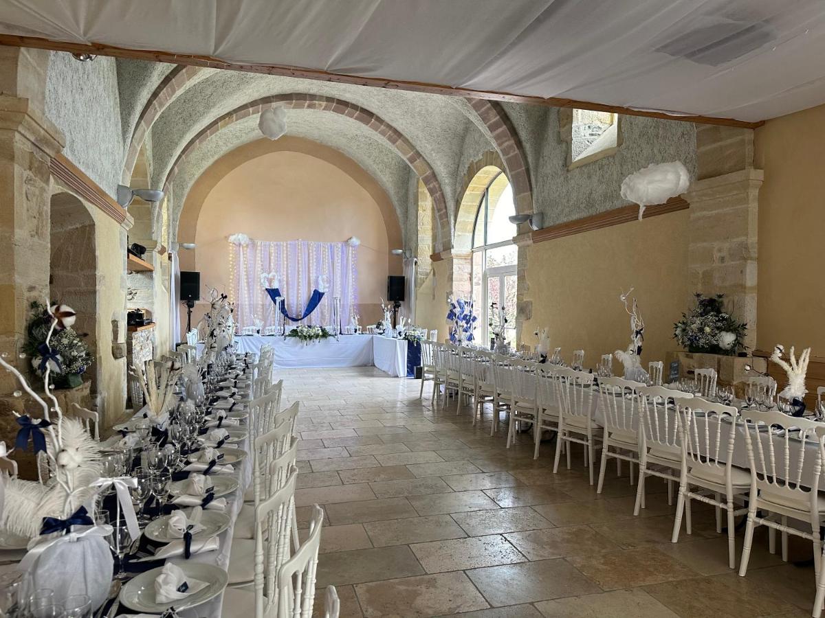 une salle de banquet avec des tables et des chaises dans un bâtiment dans l'établissement Château de la Falque, The Originals Relais, à Saint-Geniez-dʼOlt