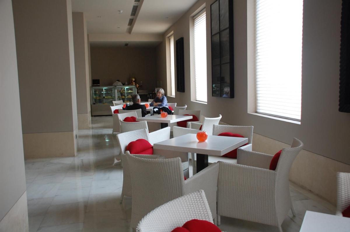 a dining room with white tables and white chairs at The LaLiT New Delhi in New Delhi