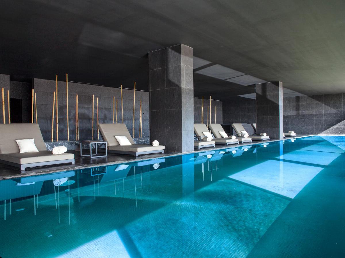uma grande piscina com uma fila de cadeiras brancas em Algarve Race Resort - Hotel em Montes de Cima
