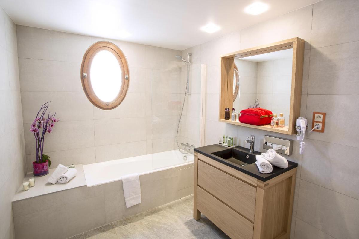 une salle de bain avec un lavabo et une baignoire dans l'établissement Cristal Hôtel & Spa, à Cannes