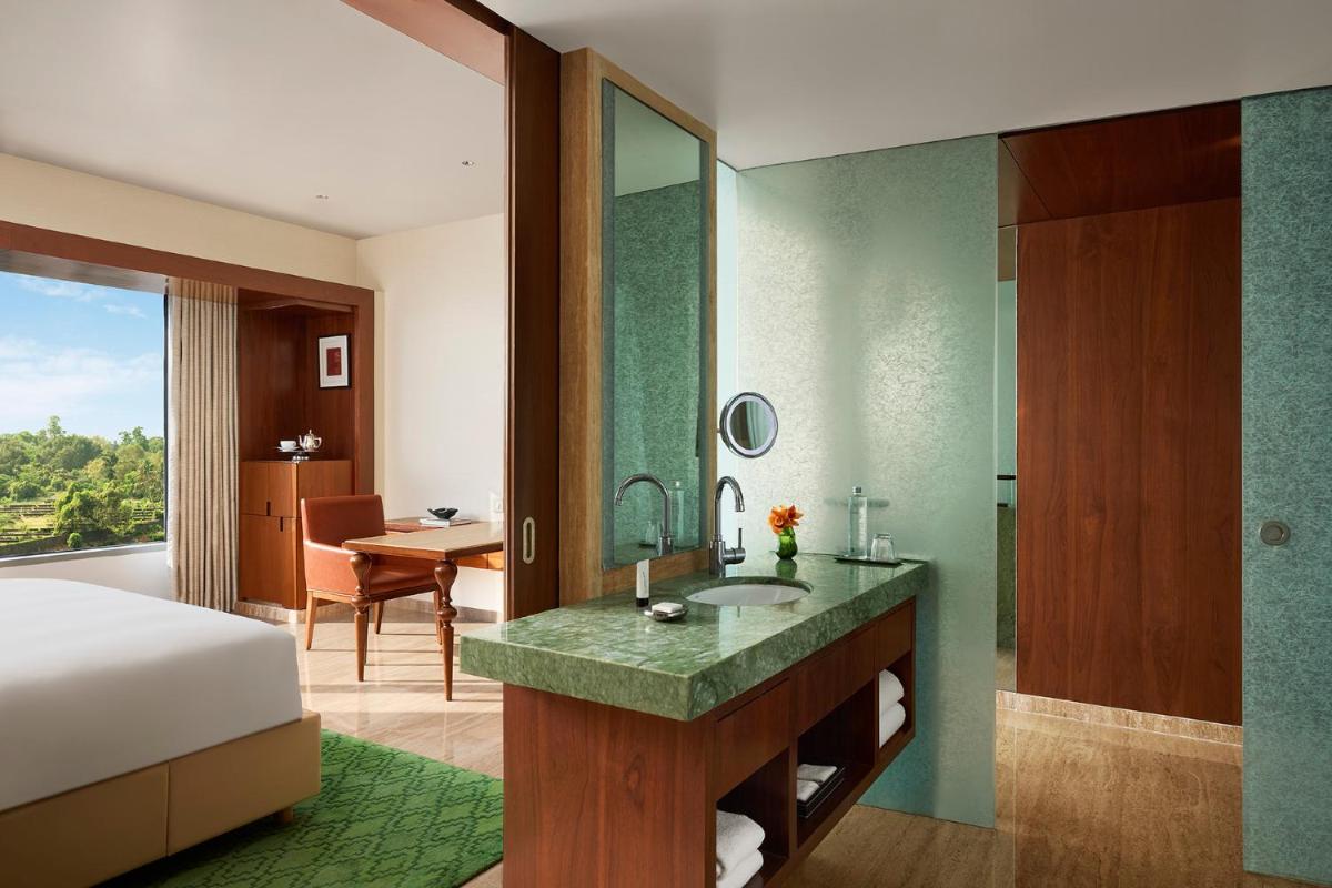 a bedroom with a bed and a bathroom with a sink at Park Hyatt Chennai in Chennai