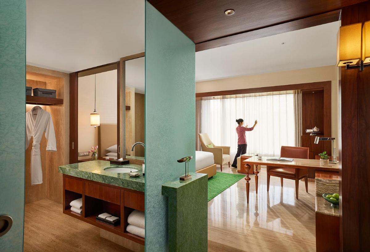 a woman is standing in a hotel room at Park Hyatt Chennai in Chennai
