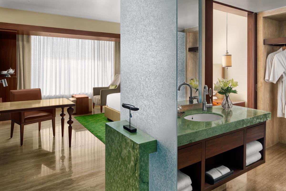 a bathroom with a sink and a room with a table at Park Hyatt Chennai in Chennai