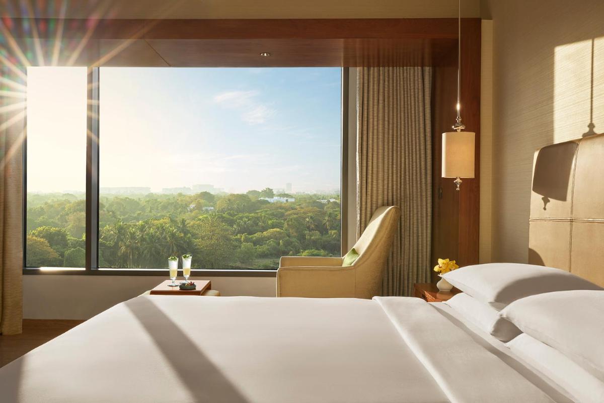 a hotel room with a bed and a large window at Park Hyatt Chennai in Chennai