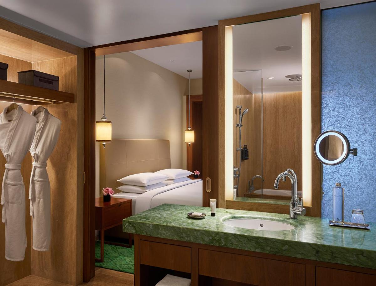 a hotel bathroom with a sink and a bed at Park Hyatt Chennai in Chennai