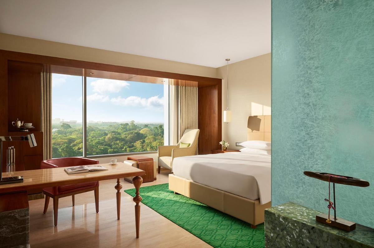 a hotel room with a bed and a desk and a window at Park Hyatt Chennai in Chennai