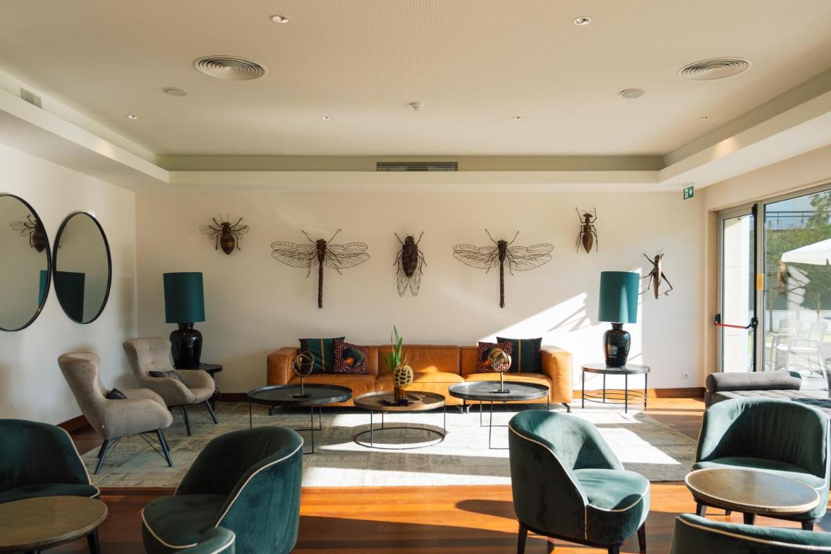 uma sala de estar com aranhas penduradas na parede em Monte Real - Hotel, Termas & Spa em Monte Real