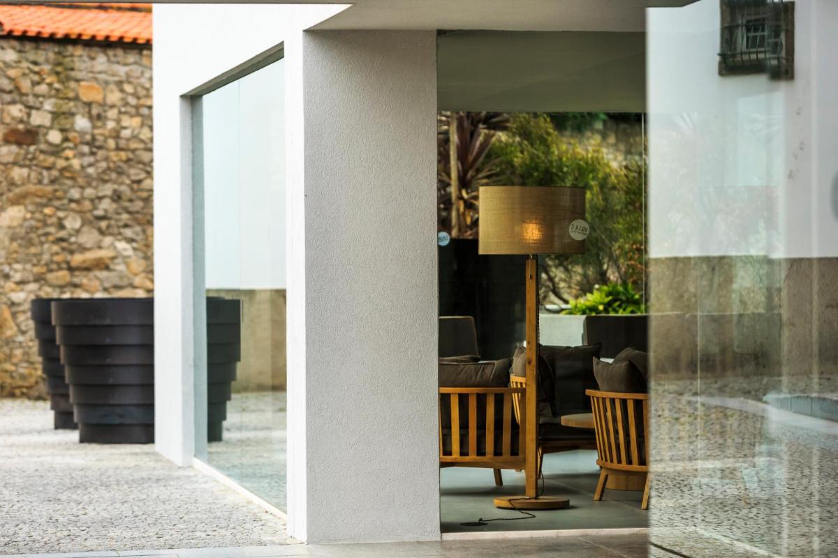 uma porta de vidro de uma casa com uma mesa e cadeiras em Villa C Boutique Hotel em Vila do Conde