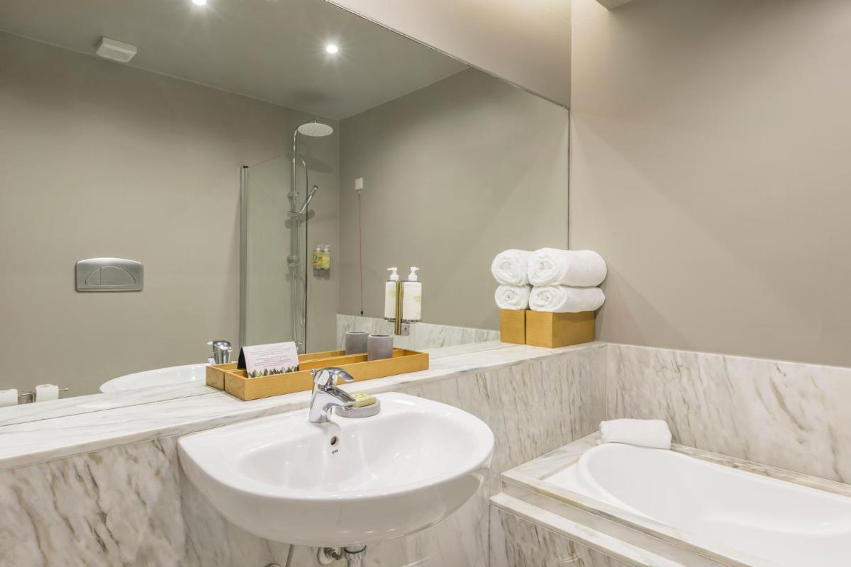 um banheiro branco com uma pia e um espelho em Villa C Boutique Hotel em Vila do Conde