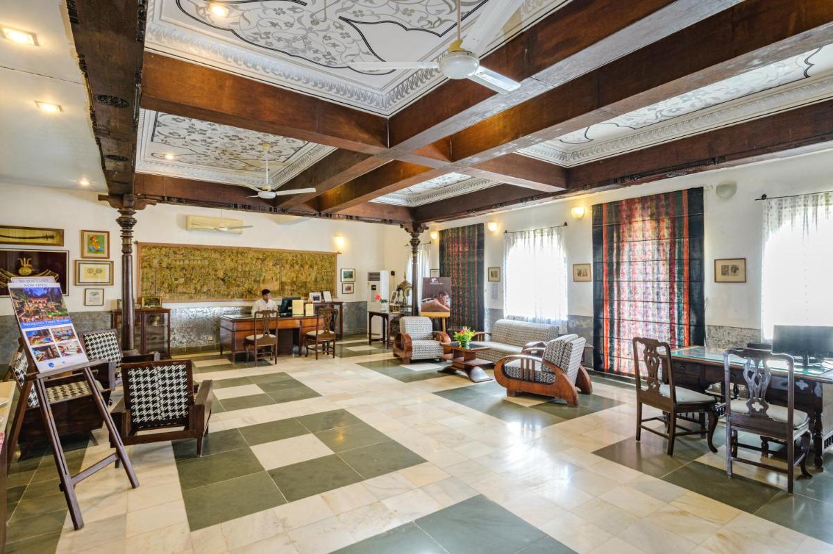 a large living room with wooden ceilings and furniture at Neemrana Fort-Palace in Neemrana