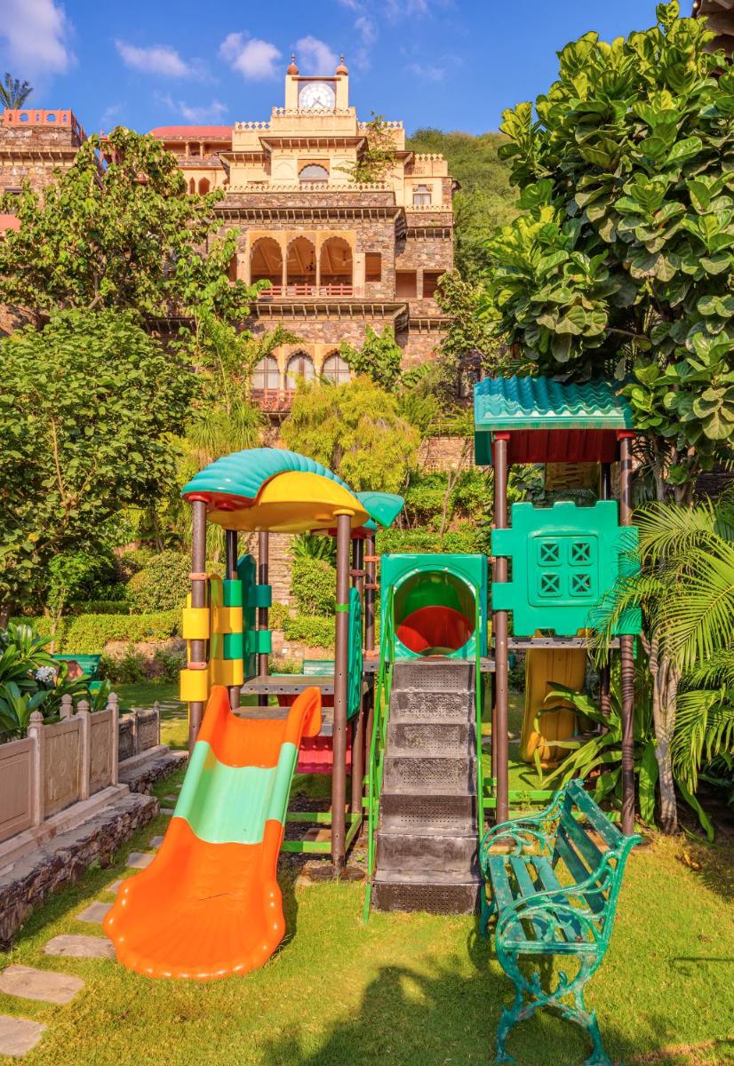 a playground with different colored equipment in front of a building at Neemrana Fort-Palace in Neemrana