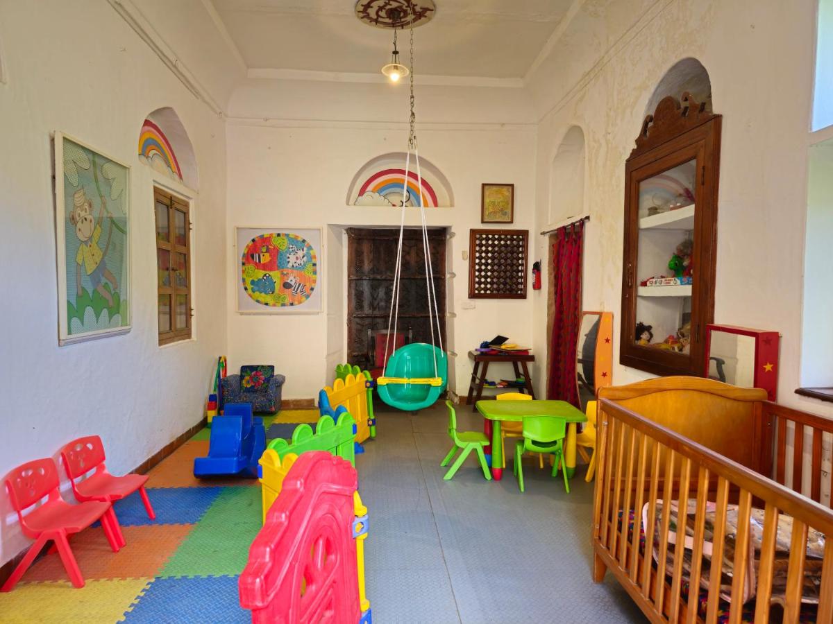 a room with colorful chairs and tables and a crib at Neemrana Fort-Palace in Neemrana