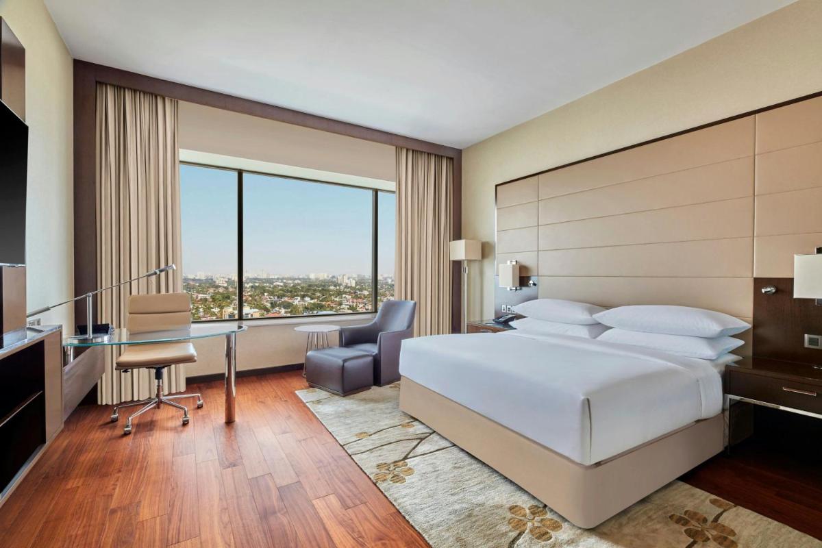 a hotel room with a bed and a desk and a desk at Kochi Marriott Hotel in Cochin