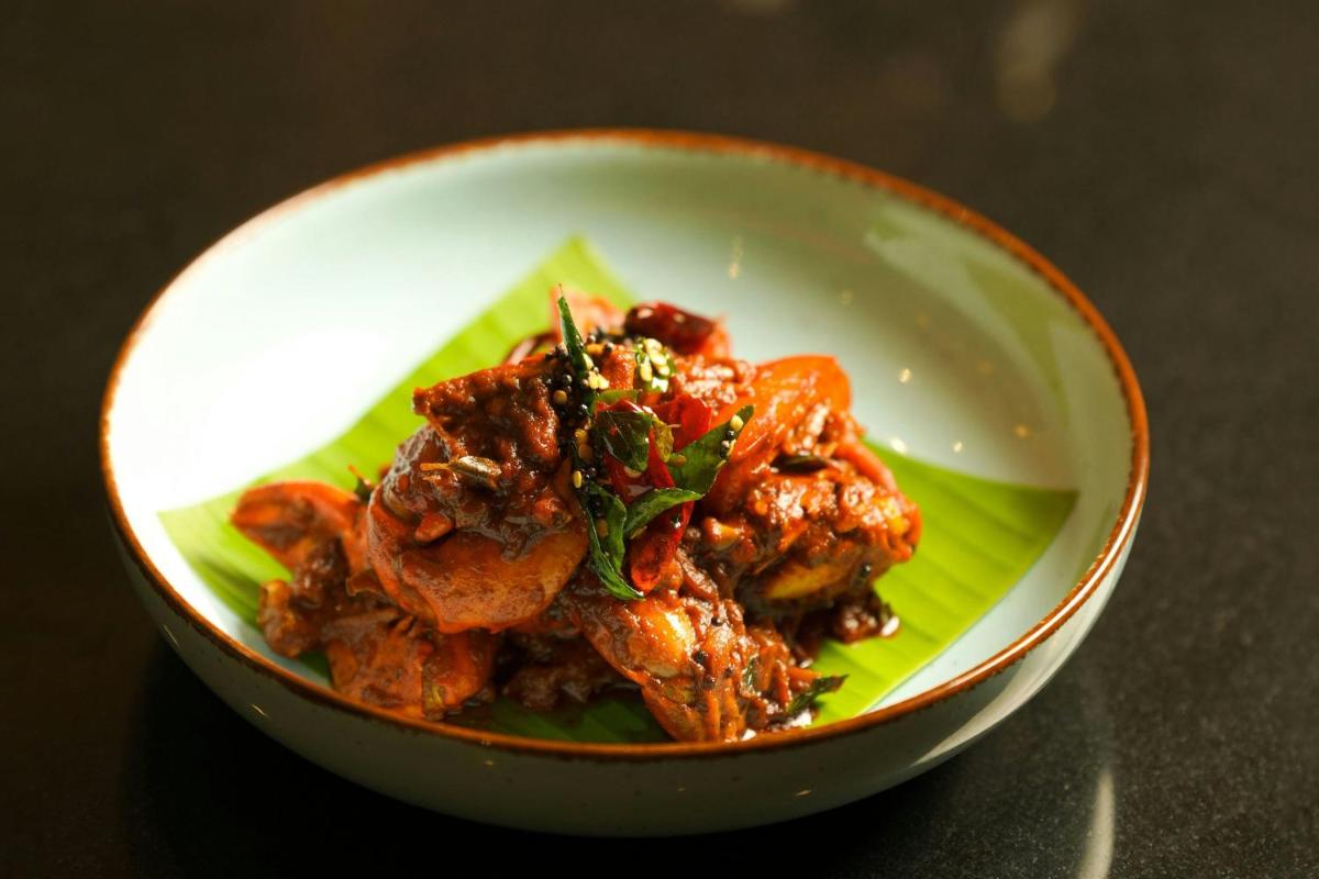 a bowl filled with food on top of a green plate at Kochi Marriott Hotel in Cochin