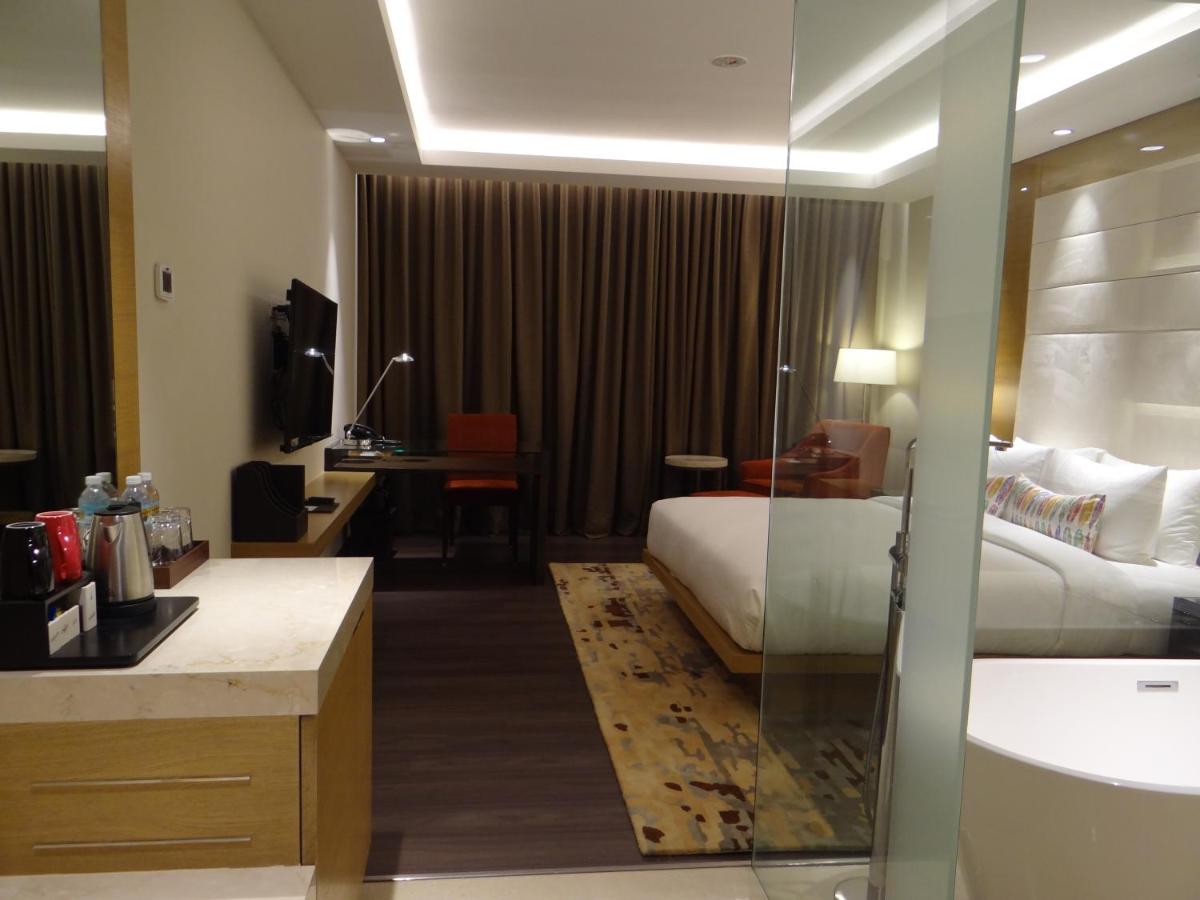 a hotel room with a bed and a desk at Feathers- A Radha Hotel, Chennai in Chennai