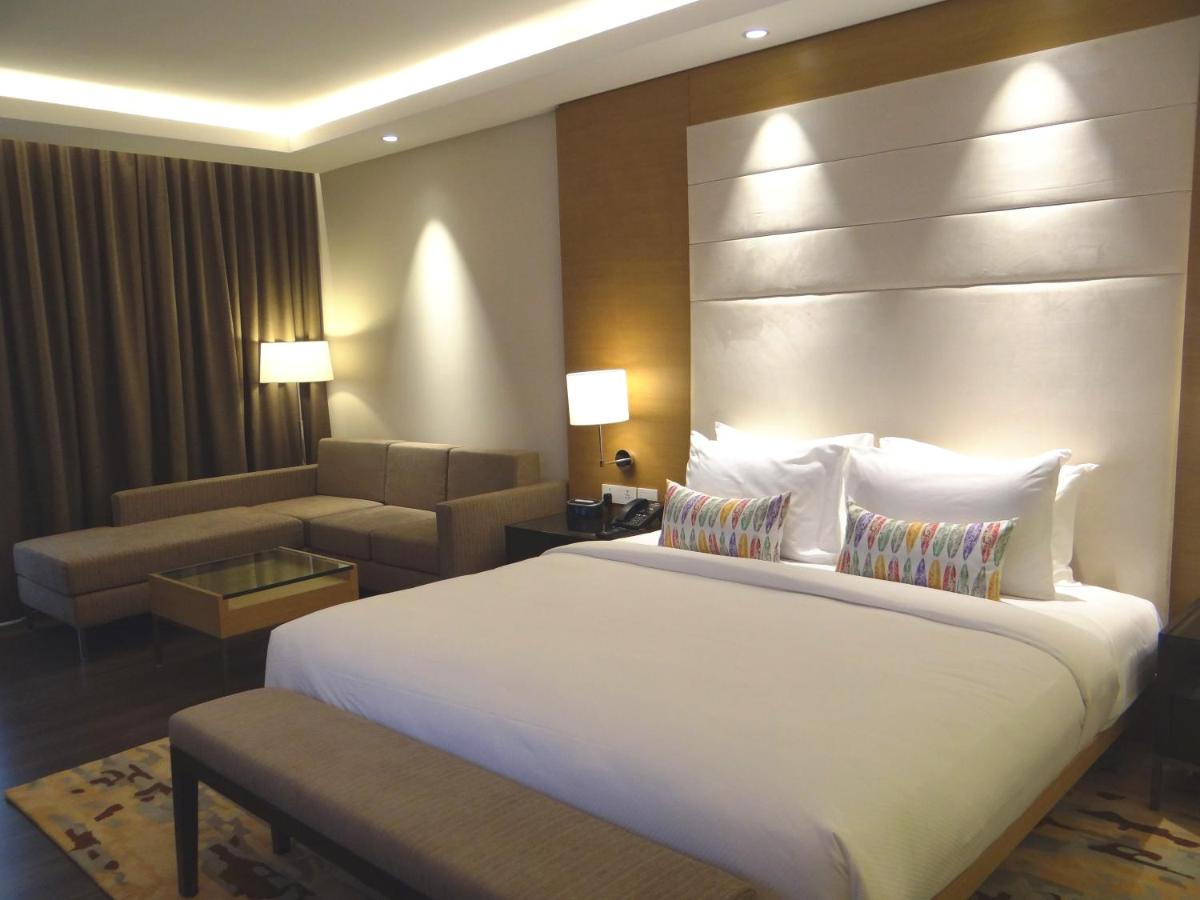 a hotel room with a large bed and a couch at Feathers- A Radha Hotel, Chennai in Chennai