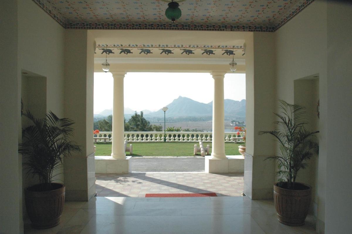 an open door to a courtyard with mountains in the background at The Lalit Laxmi Vilas Palace in Udaipur
