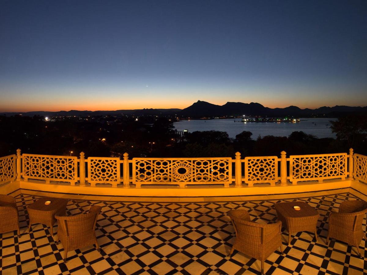 a balcony with a bench and a view of the water at The Lalit Laxmi Vilas Palace in Udaipur
