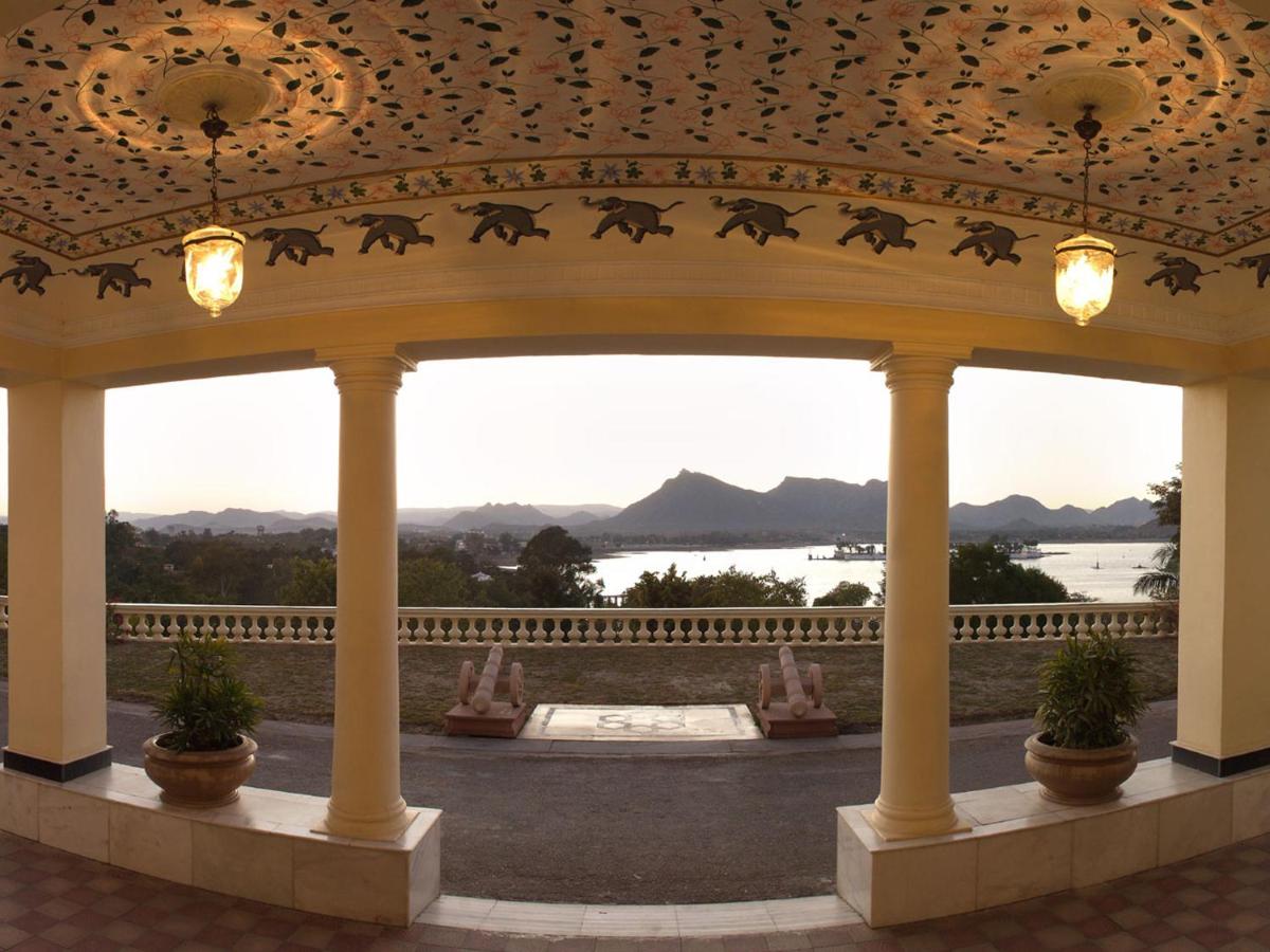 a pavilion with a view of the water and mountains at The Lalit Laxmi Vilas Palace in Udaipur