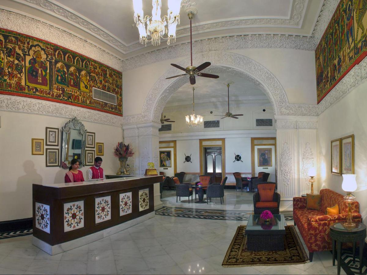 a lobby of a hotel with people standing in it at The Lalit Laxmi Vilas Palace in Udaipur