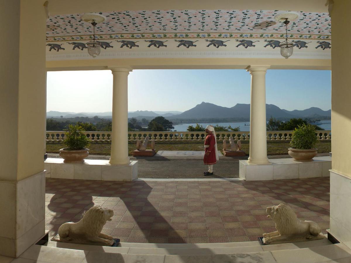 a woman standing in a pavilion with two lion statues at The Lalit Laxmi Vilas Palace in Udaipur