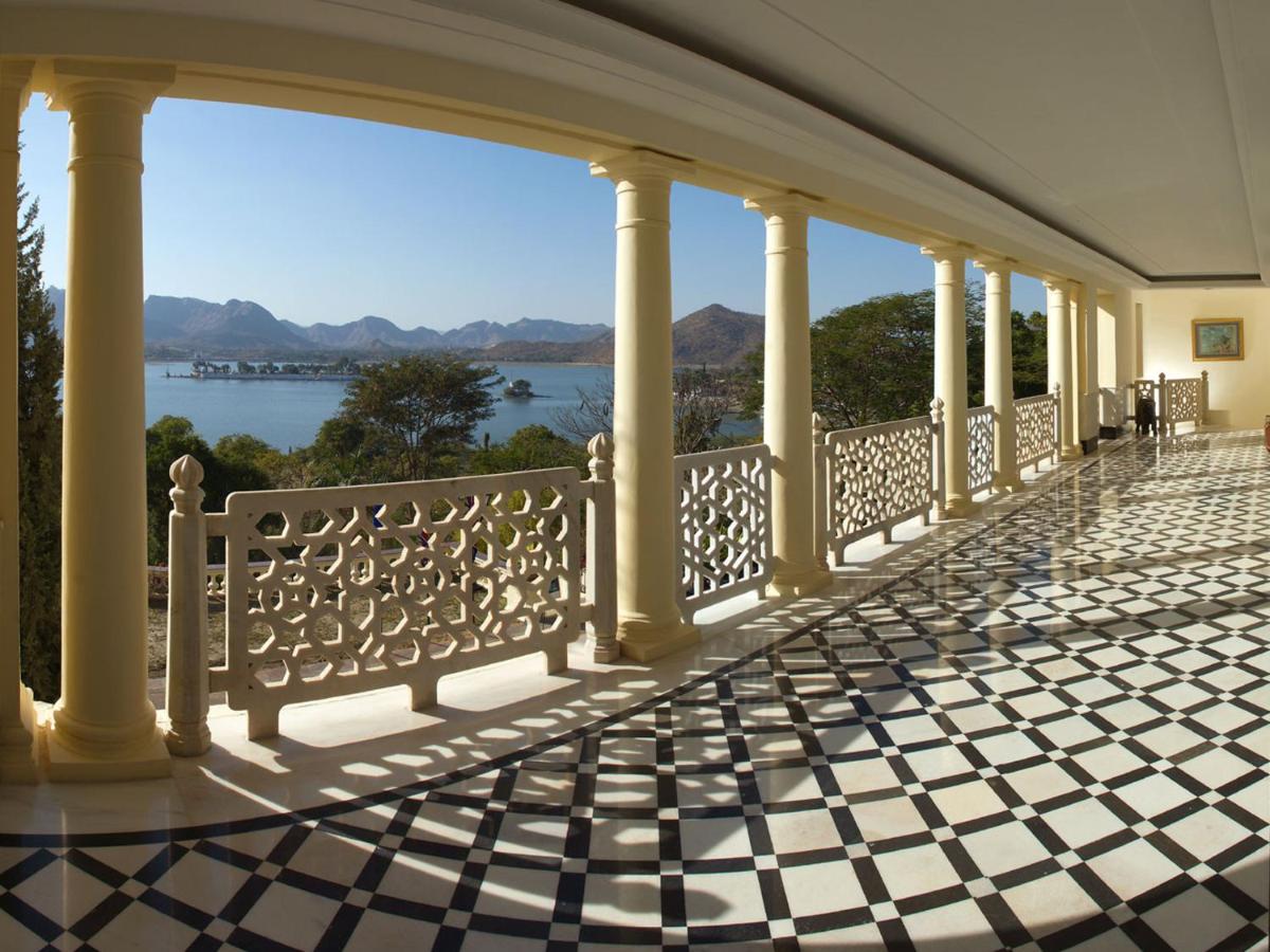 a balcony with columns and a view of the water at The Lalit Laxmi Vilas Palace in Udaipur