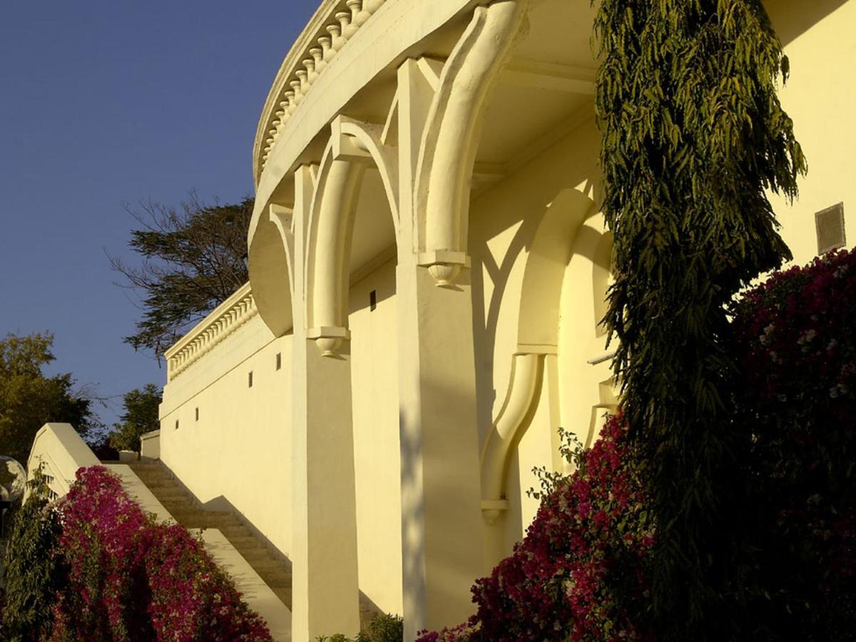 a white building with flowers in front of it at The Lalit Laxmi Vilas Palace in Udaipur