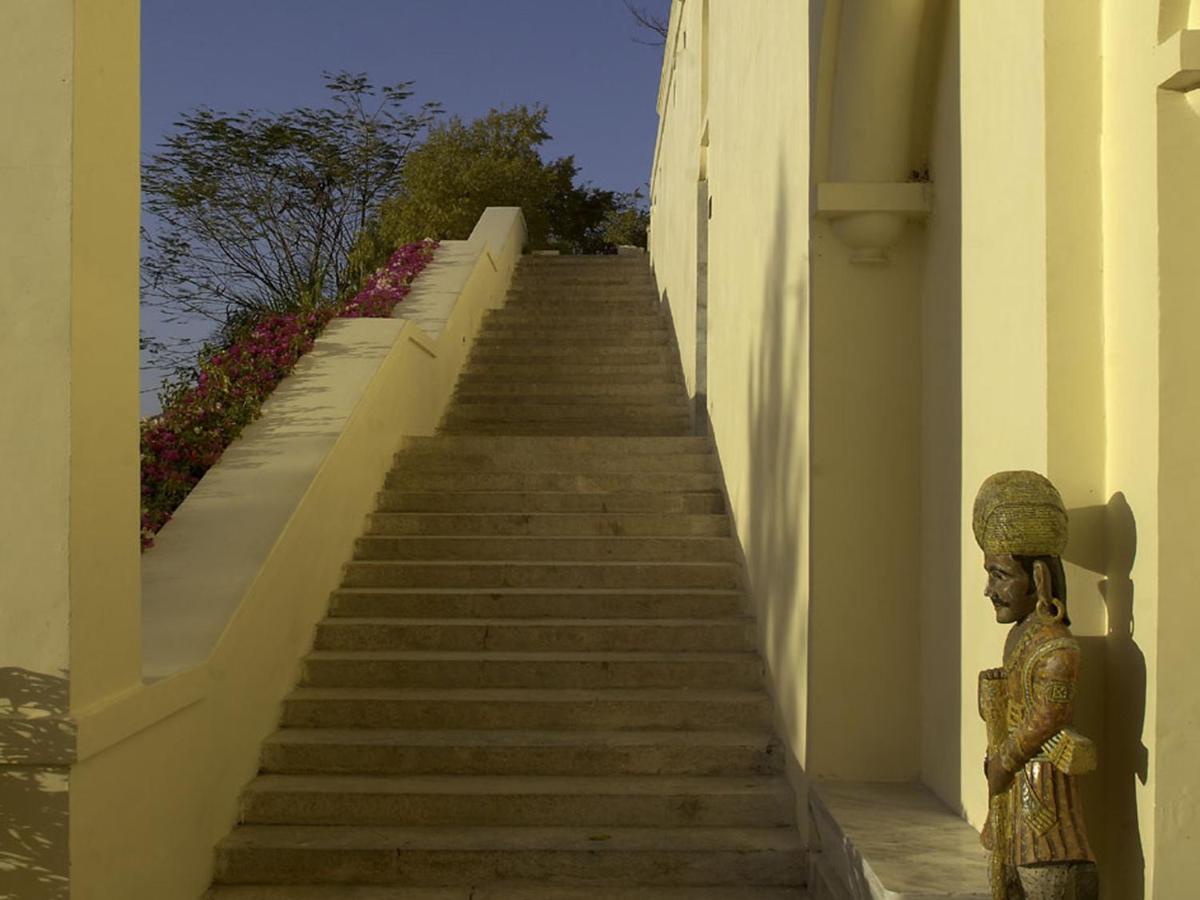 a staircase leading up to a building with a statue at The Lalit Laxmi Vilas Palace in Udaipur