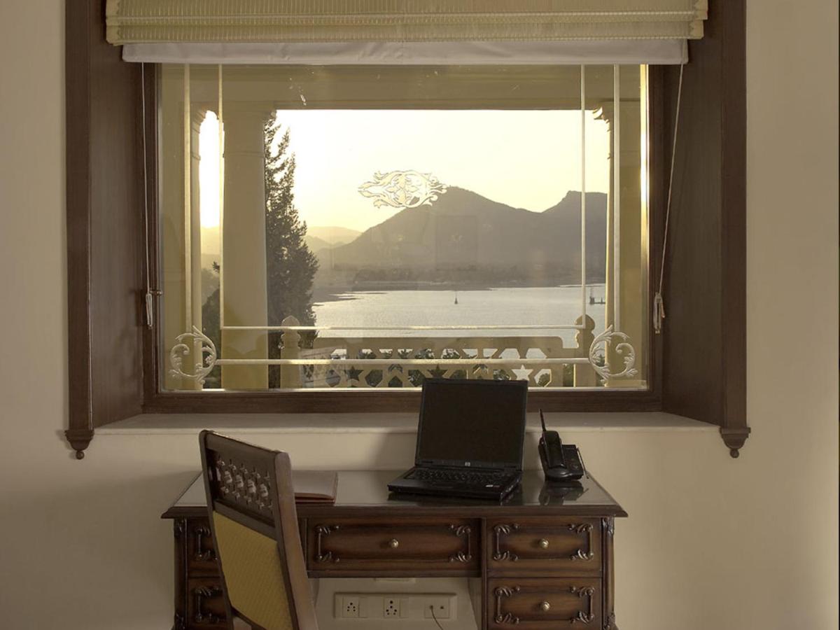 a window with a desk with a laptop on it at The Lalit Laxmi Vilas Palace in Udaipur