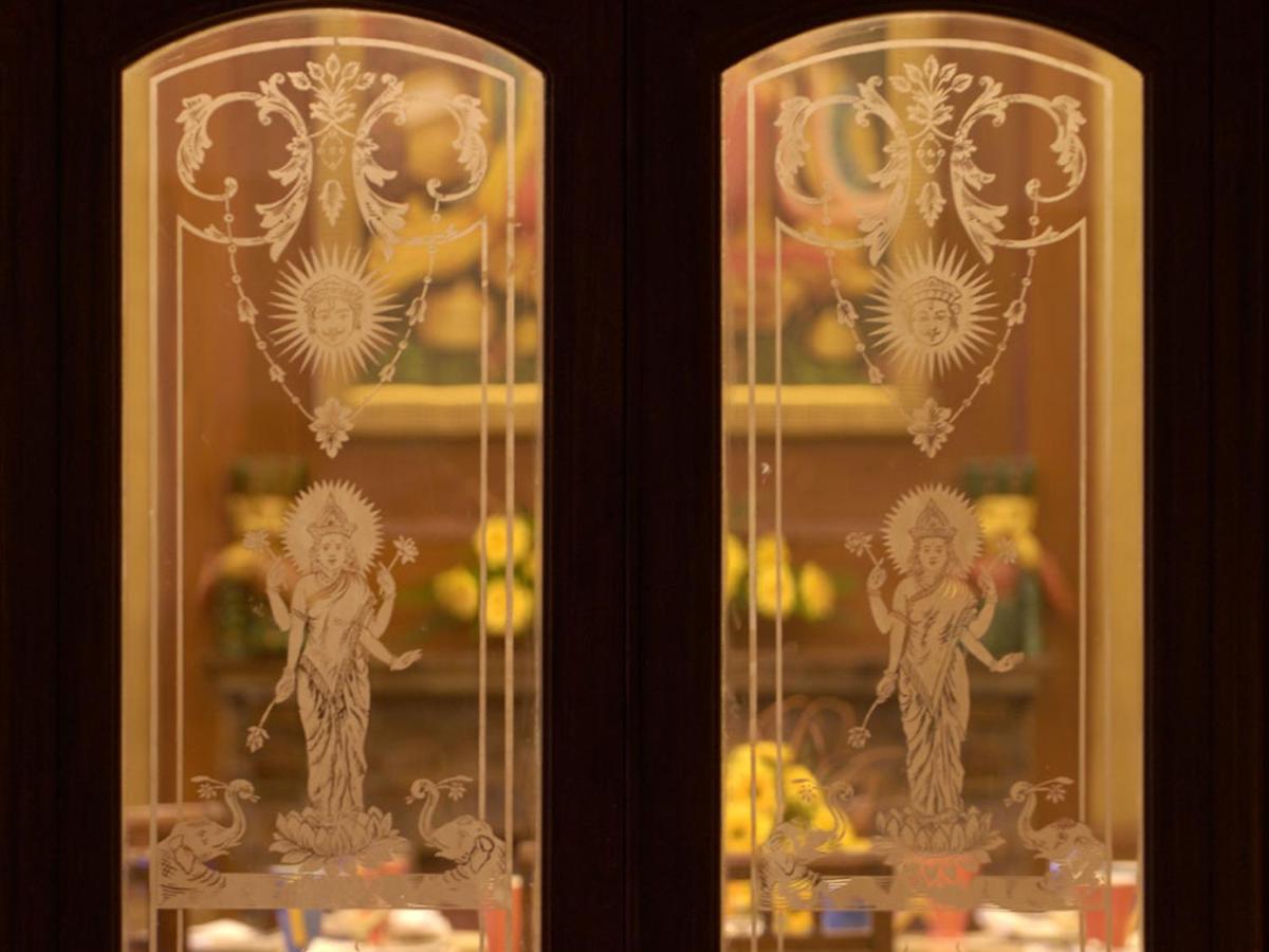 two glass doors with figurines on top at The Lalit Laxmi Vilas Palace in Udaipur