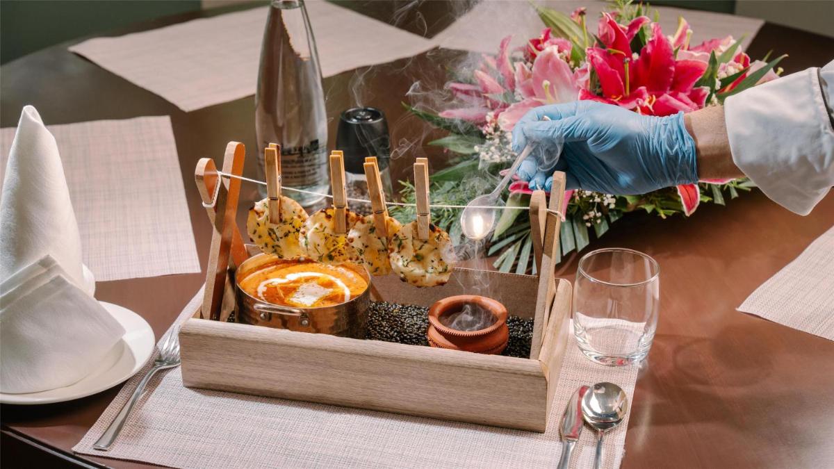 a person in a glove holding a tray of food at Radisson Blu Plaza Hotel Hyderabad Banjara Hills in Hyderabad a person in a glove holding a tray of food at Radisson Blu Plaza Hotel Hyderabad Banjara Hills in Hyderabad