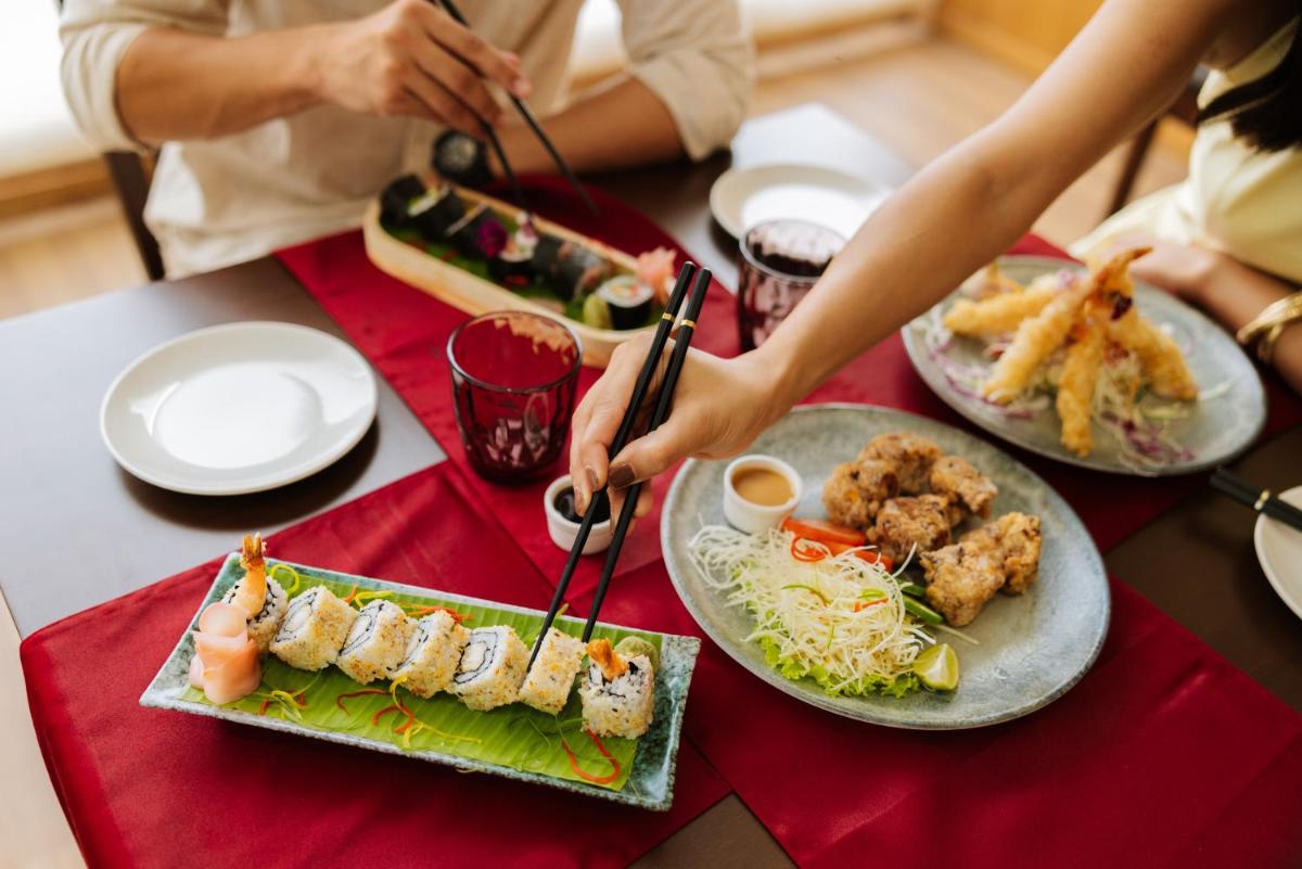 a group of people sitting at a table with plates of food at Sunday Hotel Chandigarh Zirakpur in Zirakpur