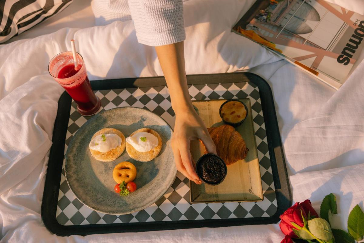 a tray with a plate of food and a drink at Sunday Hotel Chandigarh Zirakpur in Zirakpur