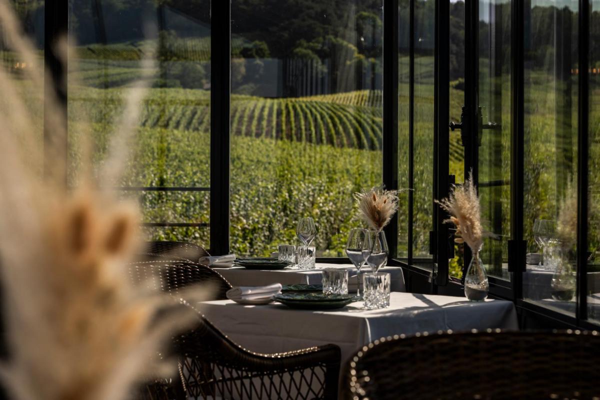 - une table avec des verres à vin et une vue sur un vignoble dans l'établissement Chateau de Sacy, à Sacy