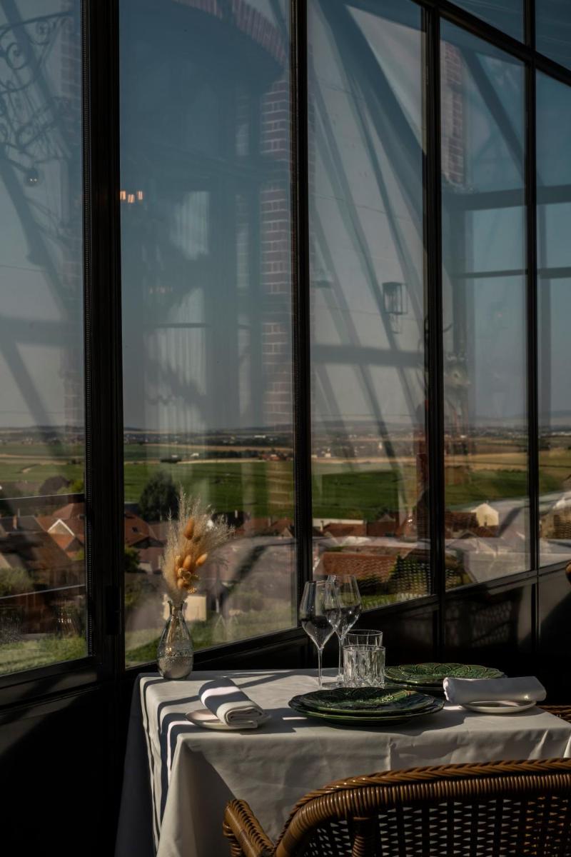 d'une table à manger avec vue sur une grande fenêtre. dans l'établissement Chateau de Sacy, à Sacy