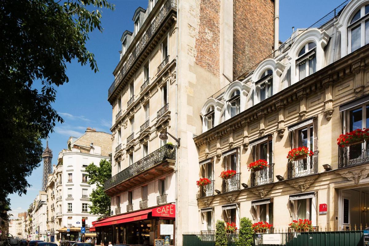 un immeuble avec des fleurs aux balcons dans une rue dans l'établissement Hotel & Spa de Latour Maubourg, à Paris