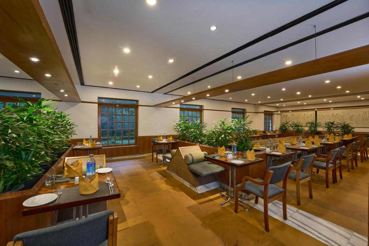 a restaurant with tables and chairs in a room at Casino Hotel - CGH Earth, Cochin in Cochin