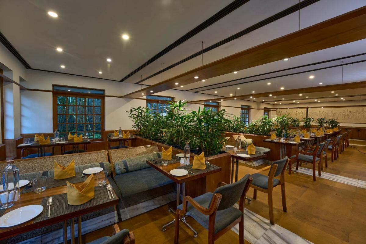 a restaurant with tables and chairs in a room at Casino Hotel - CGH Earth, Cochin in Cochin