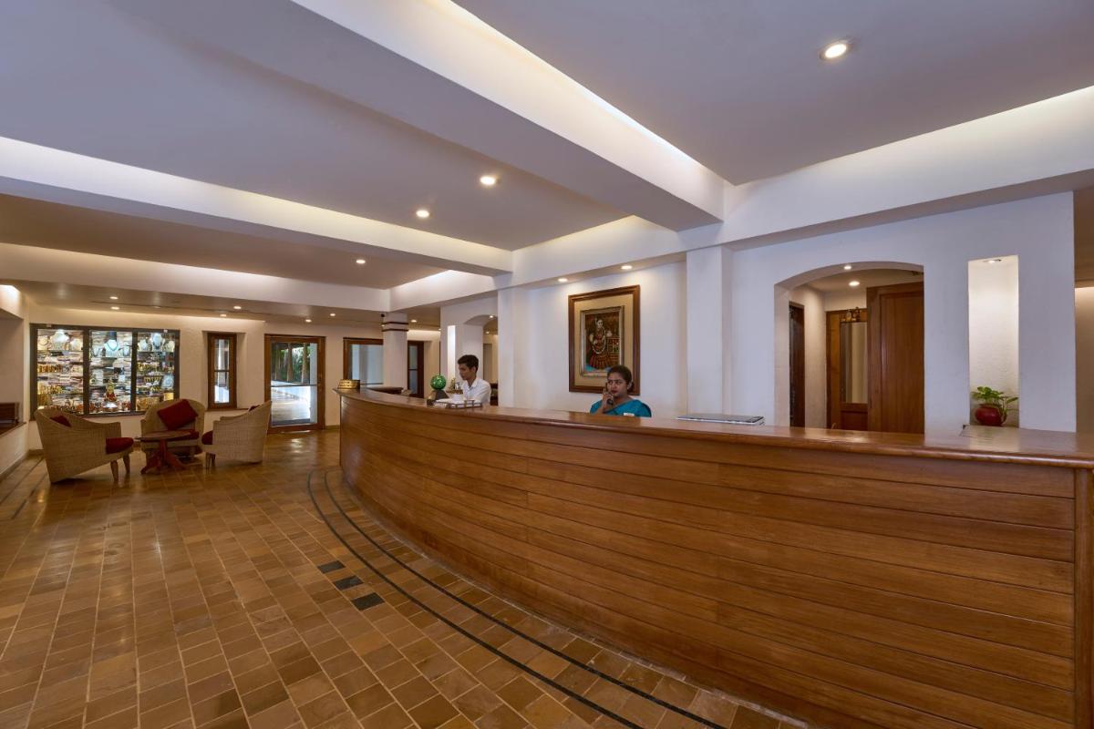 a woman sitting at a bar in a hotel lobby at Casino Hotel - CGH Earth, Cochin in Cochin