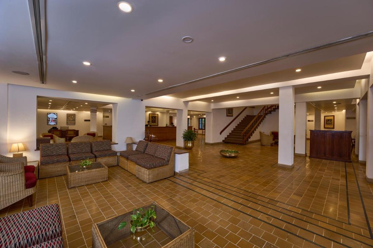 a lobby with couches and a staircase in a building at Casino Hotel - CGH Earth, Cochin in Cochin