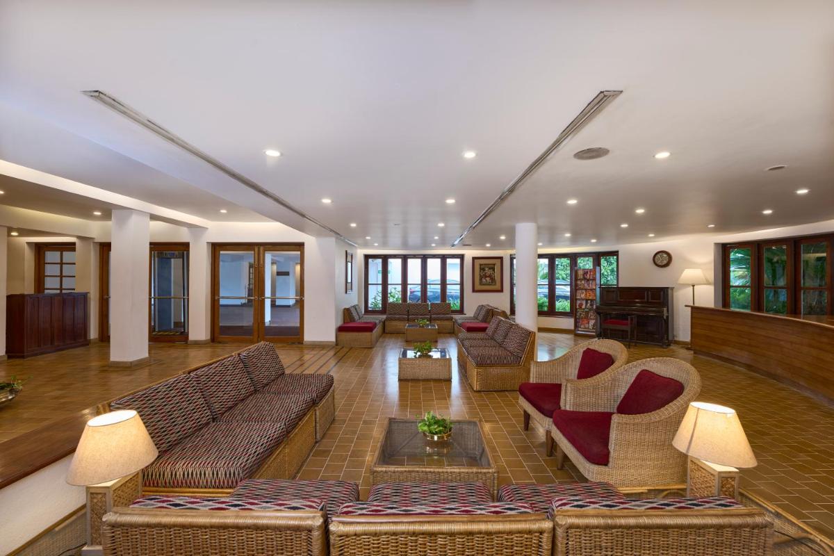 a living room with couches and chairs in a building at Casino Hotel - CGH Earth, Cochin in Cochin
