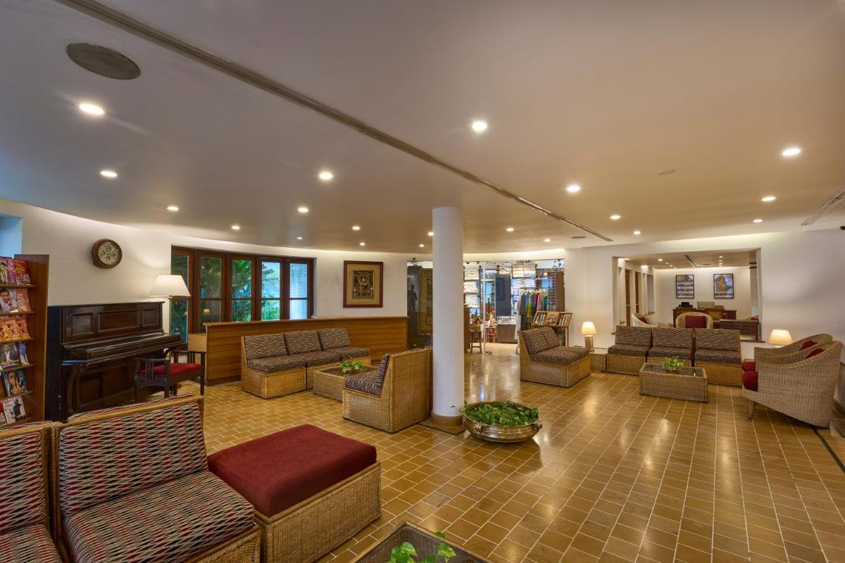 a large living room with couches and a piano at Casino Hotel - CGH Earth, Cochin in Cochin