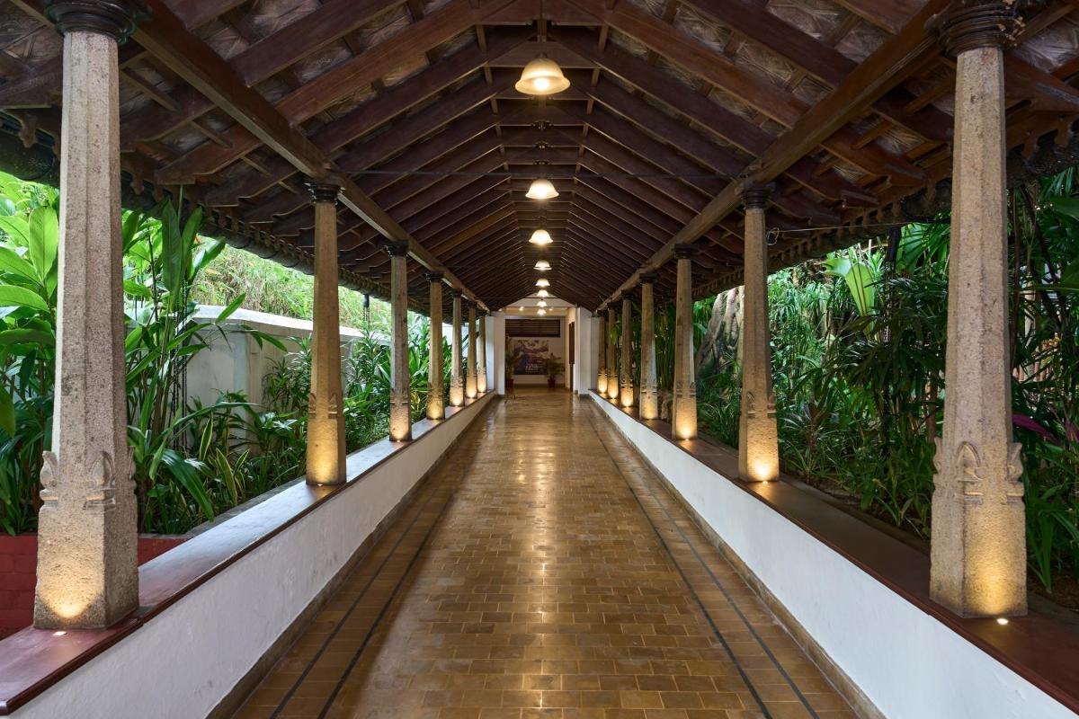 a walkway in the middle of a building with columns at Casino Hotel - CGH Earth, Cochin in Cochin