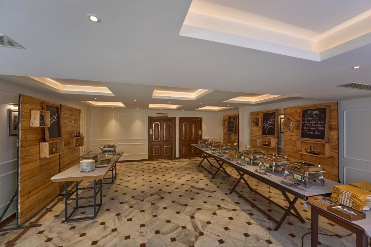a large room with tables and a chalkboard on the wall at Casino Hotel - CGH Earth, Cochin in Cochin