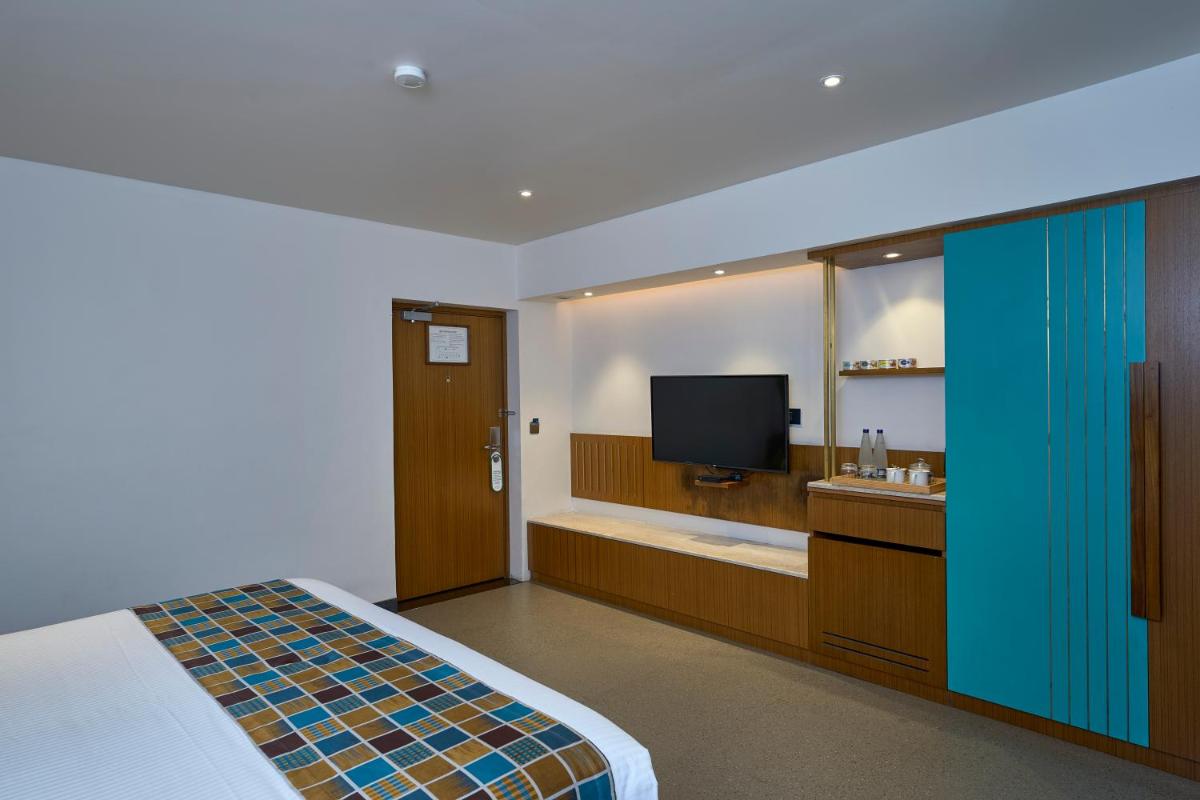 a hotel room with a bed and a tub and a television at Casino Hotel - CGH Earth, Cochin in Cochin