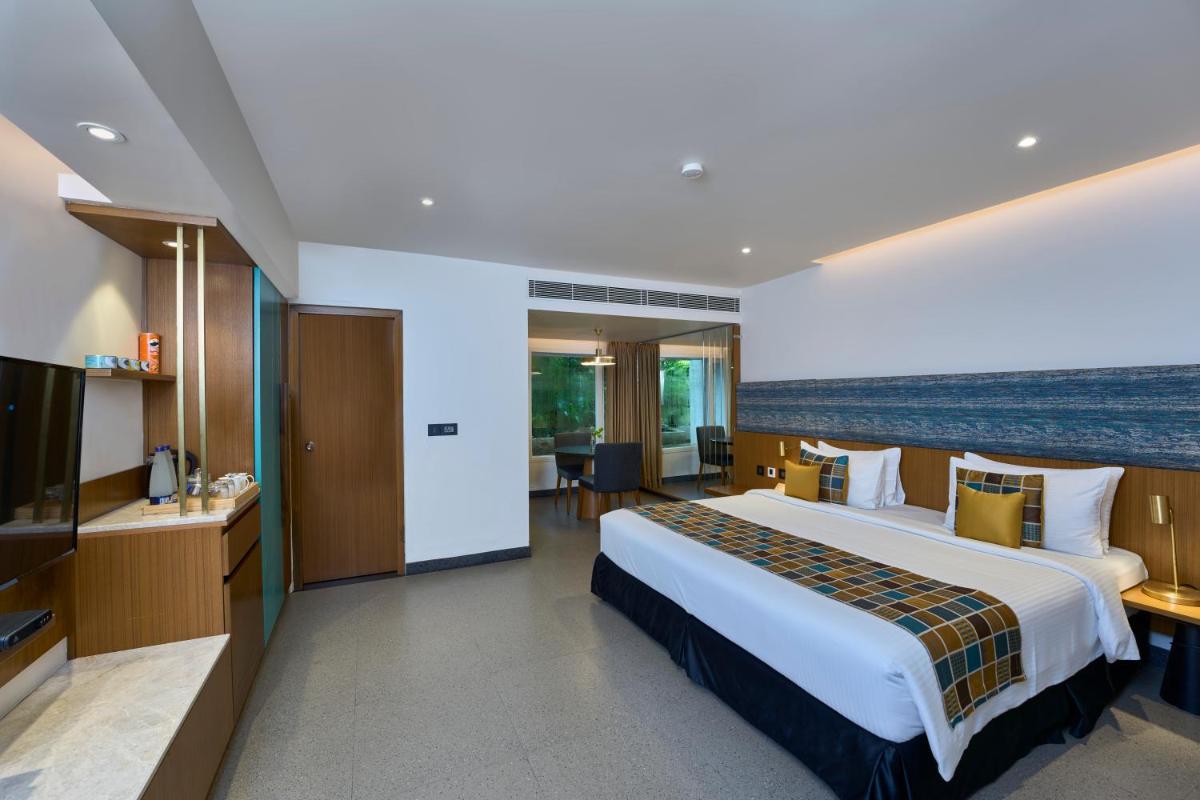 a hotel room with a large bed and a television at Casino Hotel - CGH Earth, Cochin in Cochin
