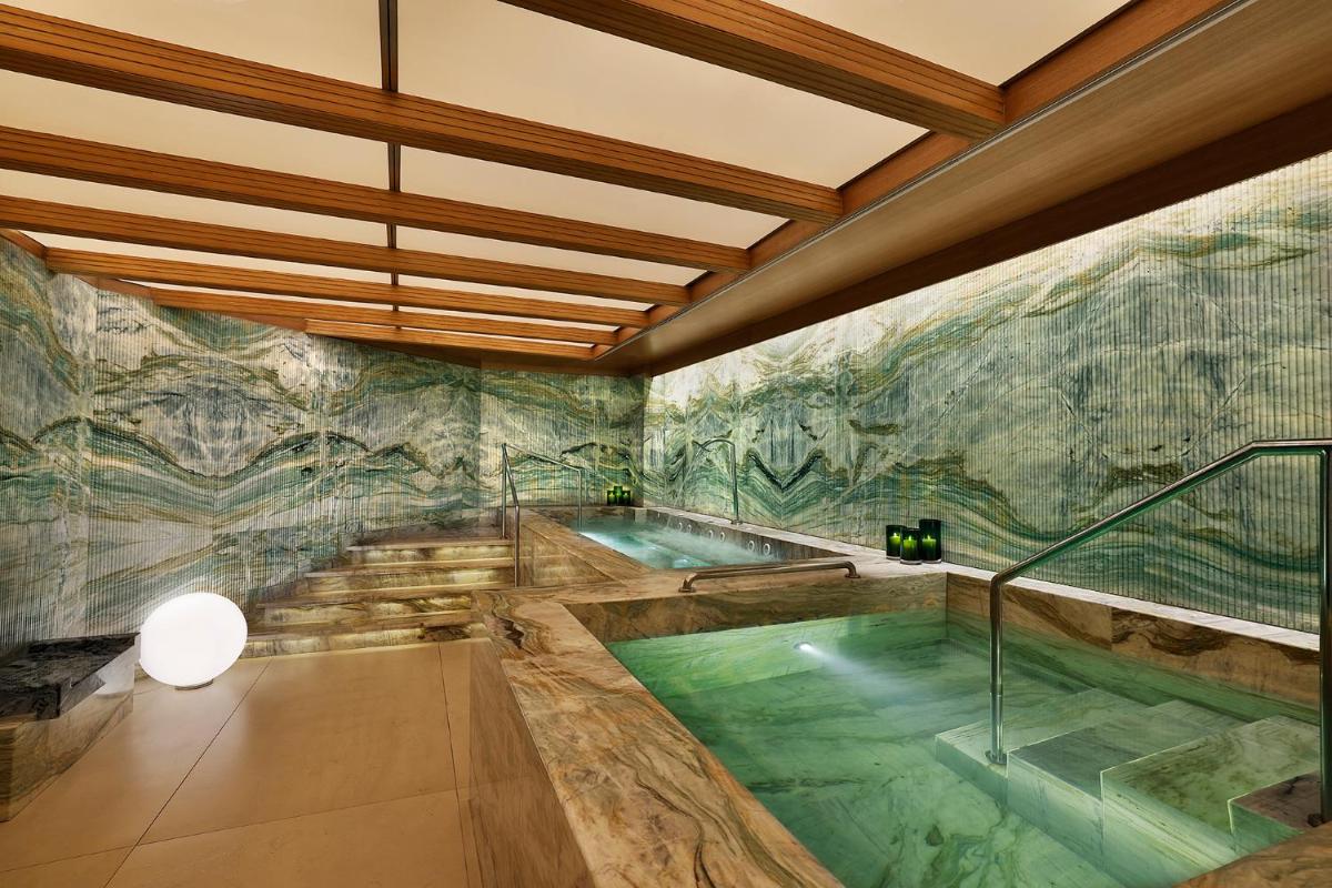 a large indoor pool in a room with a painting on the wall at Shangri-La Eros New Delhi in New Delhi a large indoor pool in a room with a painting on the wall at Shangri-La Eros New Delhi in New Delhi