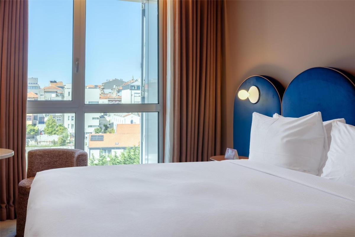 Uma cama ou camas num quarto em Cenica Porto Hotel, Curio Collection By Hilton
